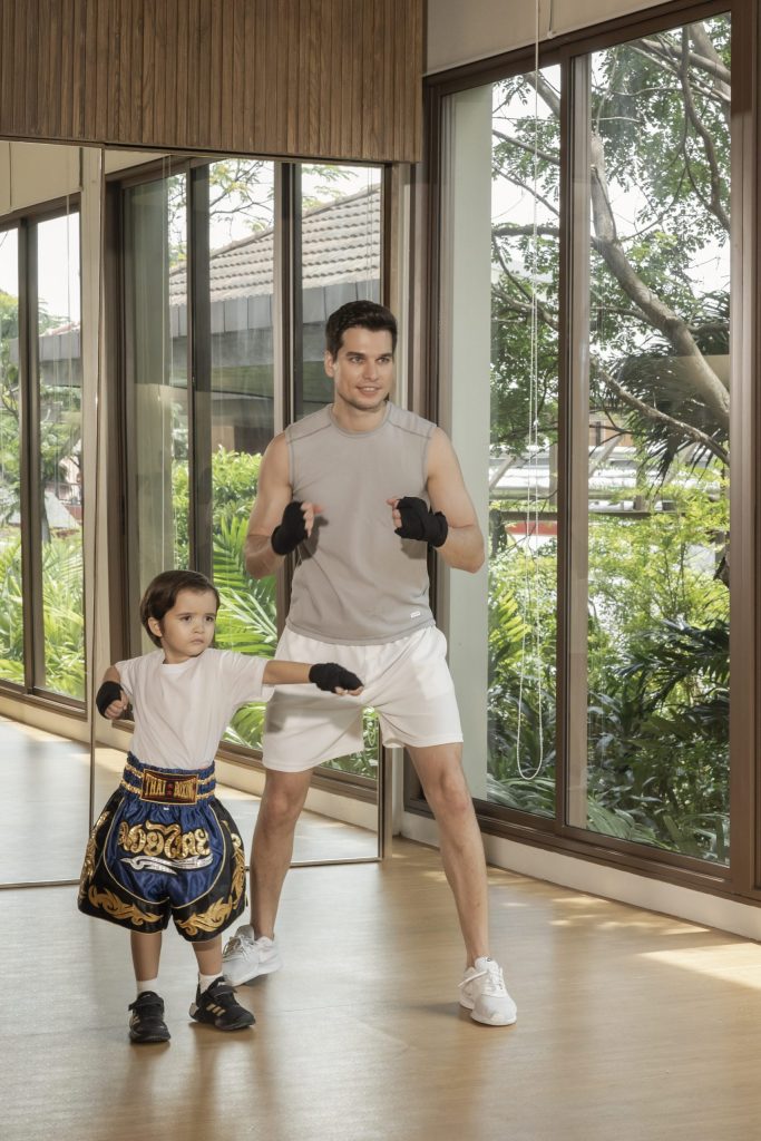 Muay Thai training for kids and families at RXV Wellness Village, guided by a professional instructor in a bright fitness studio.