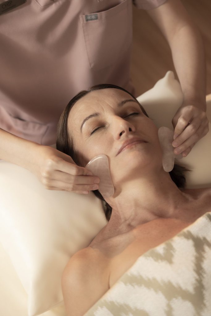 Facial gua sha treatment at RXV Wellness Village, promoting relaxation and radiant skin through ancient healing techniques.