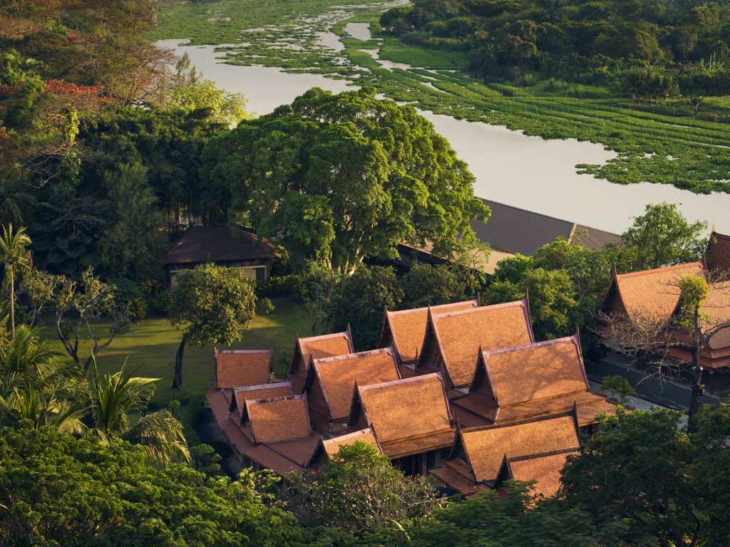 Aerial view of RXV Wellness Village’s Thai-style architecture surrounded by lush greenery and riverside landscape, reflecting serenity and mindful living.