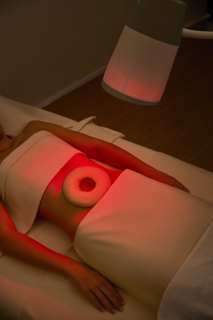 Woman receiving red light belly therapy for gut healing at RXV Wellness Village.