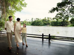 A family walking together by the riverside at RXV Wellness Village Sampran.