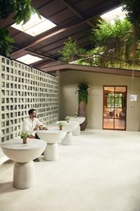 Man relaxing with a drink in the serene lounge area at RXV Wellness Village Sampran.