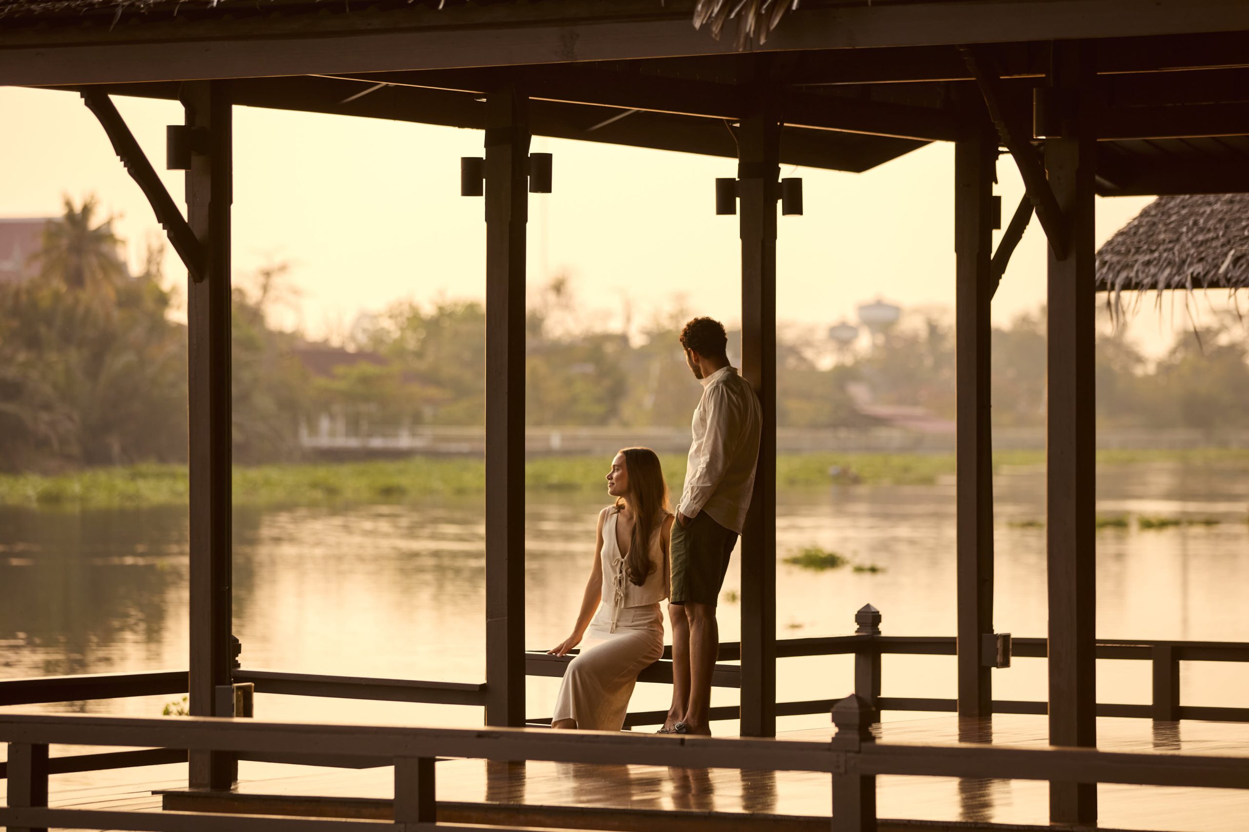 Couple enjoying sunset by the riverside pavilion at RXV Wellness Village Sampran.