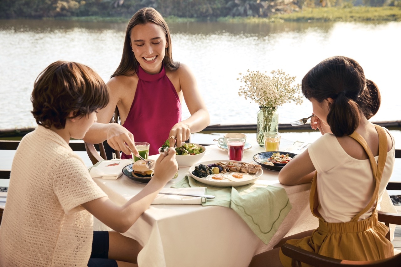 Family enjoying a healthy breakfast by the riverside at RXV Wellness Village Sampran.