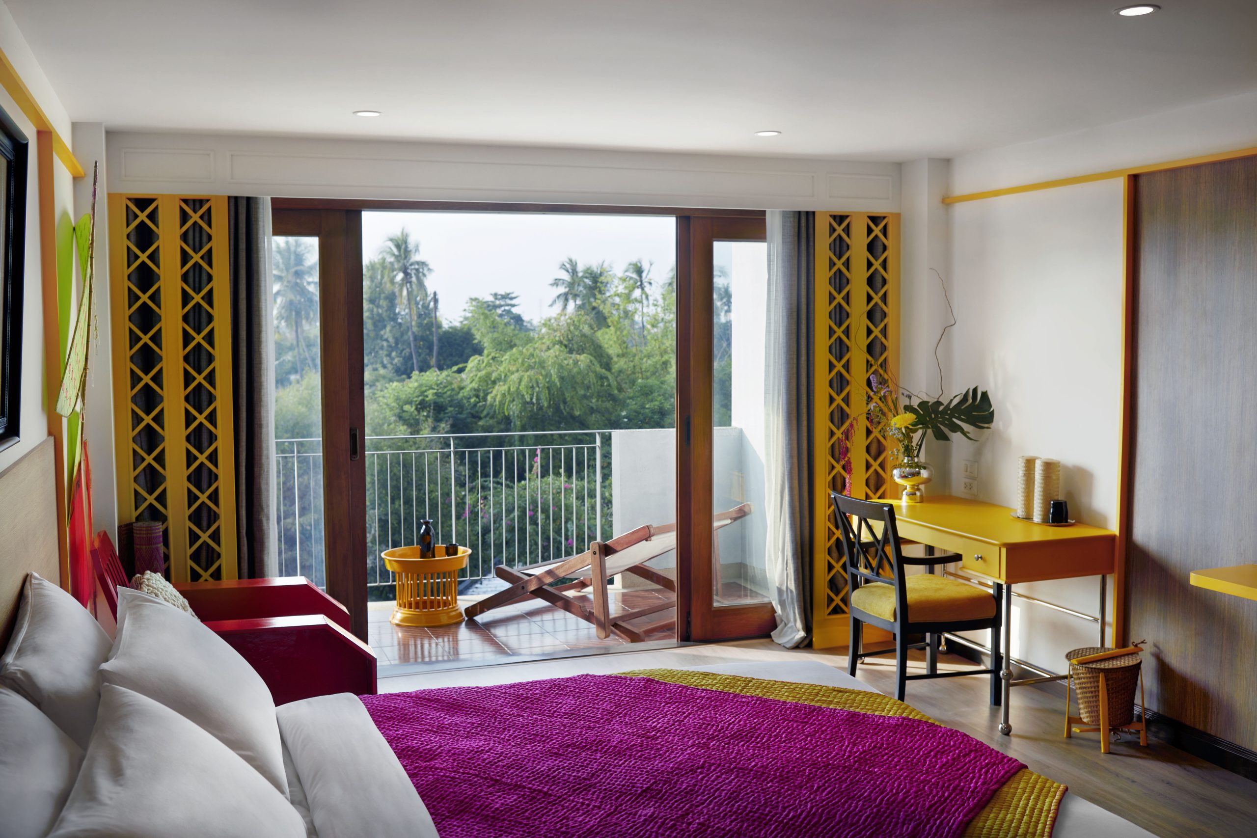 Bright and colorful wellness room with balcony and garden view at RXV Wellness Village Sampran.