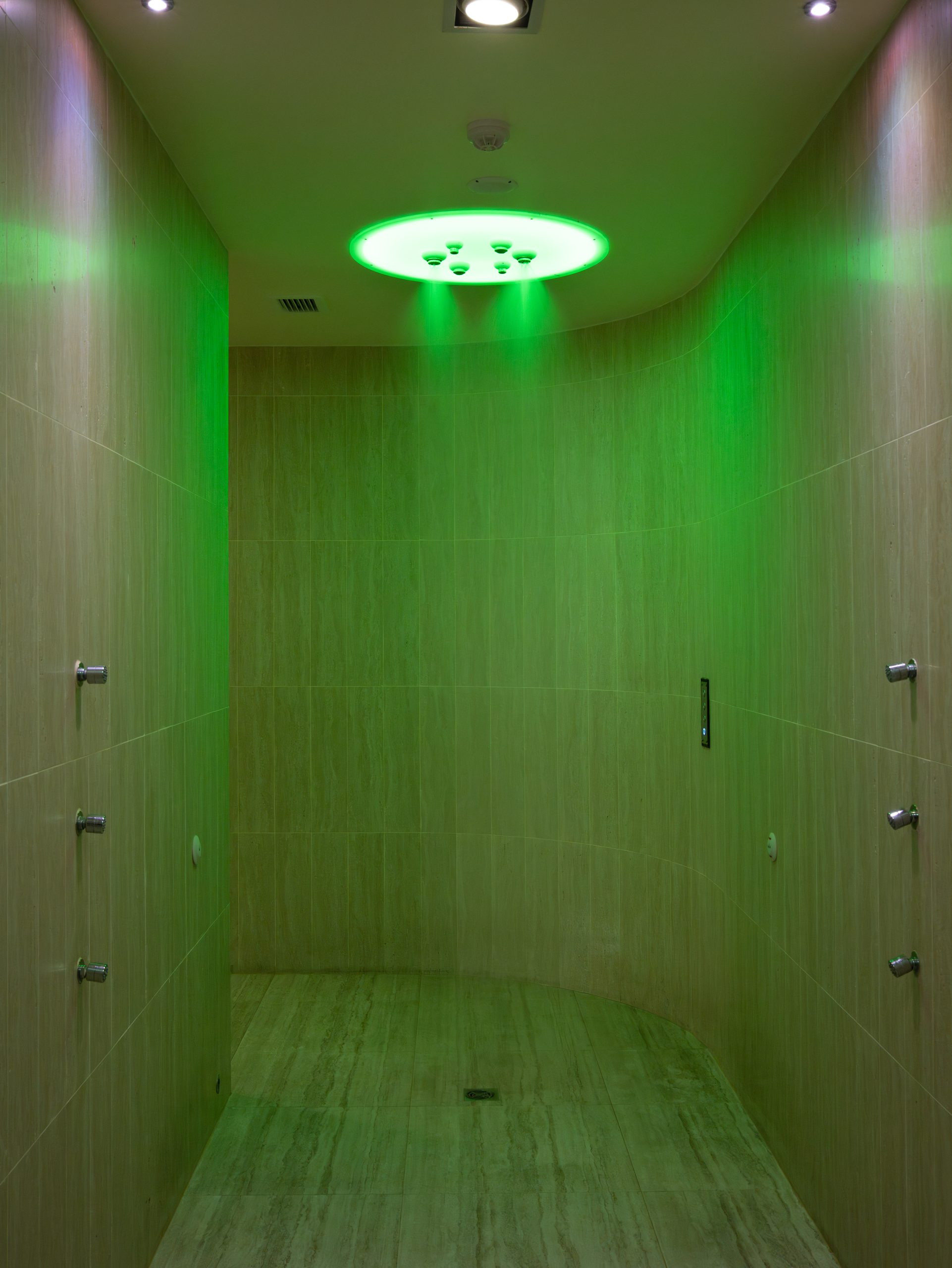 Chromotherapy shower room with calming green light at RXV Wellness Village Sampran.