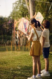 Children painting on transparent canvas outdoors at RXV Wellness Village Sampran.