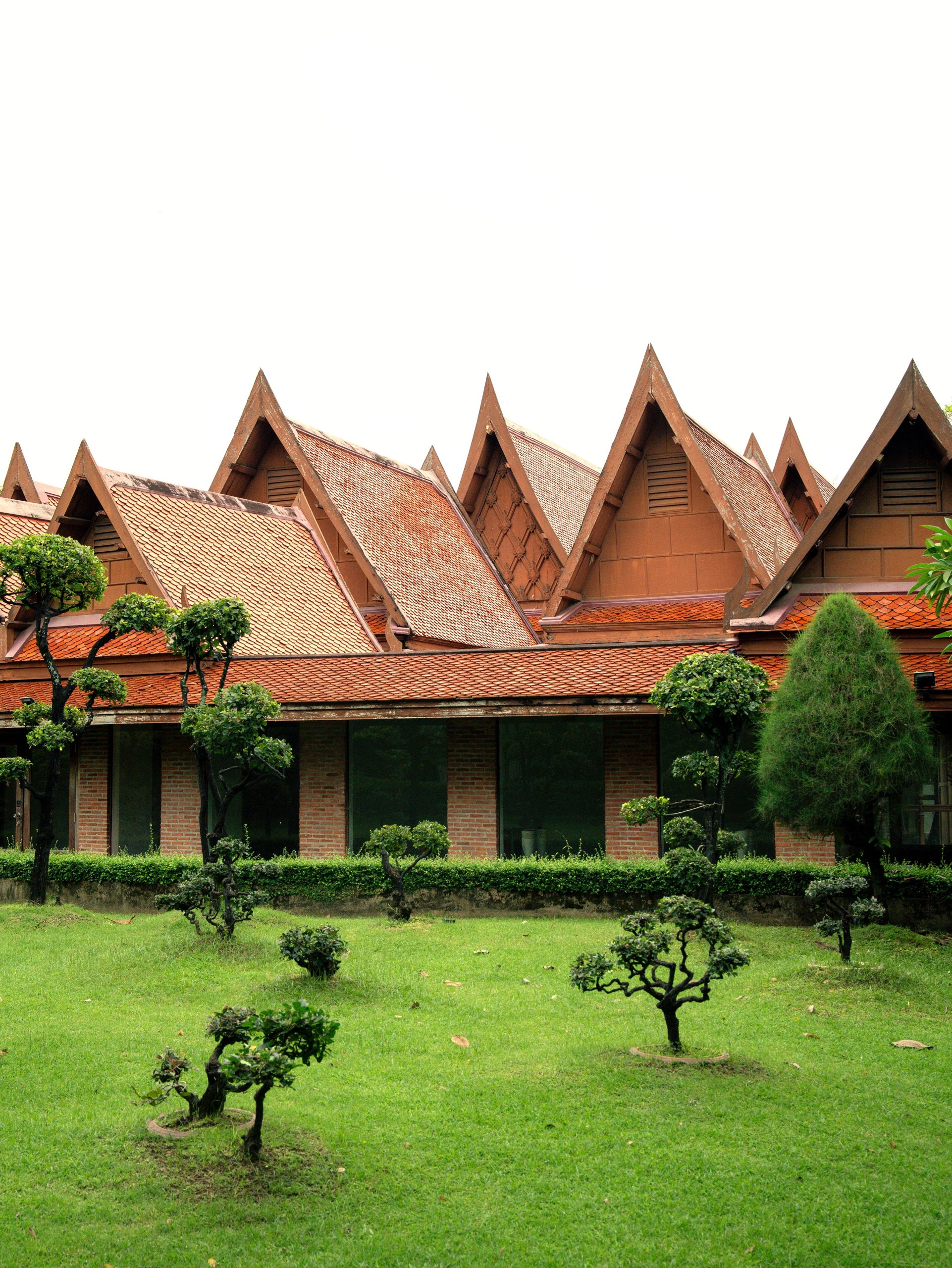 Traditional Thai-style roof architecture surrounded by manicured gardens at RXV Wellness Village Sampran.